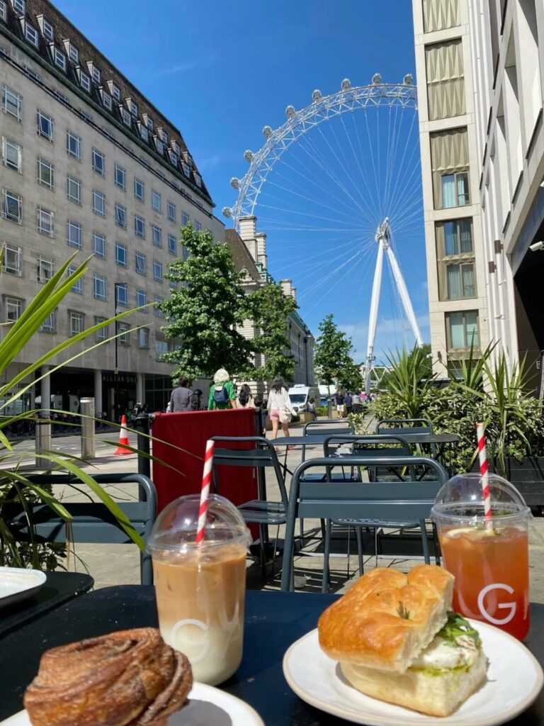 Iced coffee and food on a table with the London Eye in background