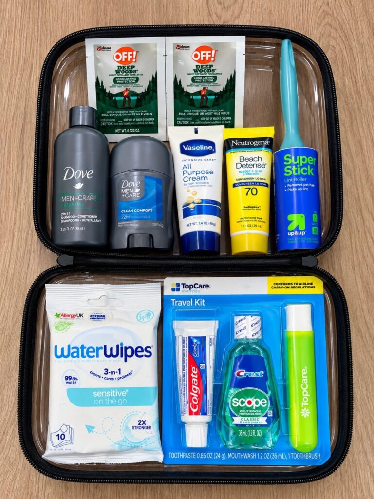 Open black toiletry bag filled with travel-sized soaps, sunscreen, and dental care products.